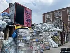 Recyclables are stacked, palleted, and stored in shipping containers before pick-up.