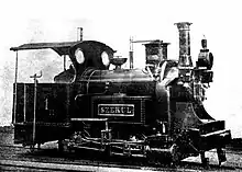 Historical black and white photo of the first steam locomotive running in Romania, the SZEKUL