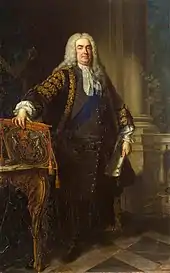 In a full-length portrait, an overweight middle-aged man stands, legs slightly apart, with his right hand resting on the top of a coat of arms, leant on the top of an ornate table.  In his left hand he holds a large white document.  He is dressed in expensive 18th-century clothing, with a blue sash over his left shoulder, and a long grey wig.  Behind him, a large pale column of stone rises from a tiled floor.  A balustrade connects to the column, and a small green plant is visible.