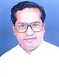 Smiling, bespectacled younger priest