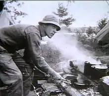 photo of a young man cooking outdoors