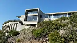 View of Hangover House from Ceanothus Drive. The word "HANGOVER" is stamped in the concrete retaining wall.