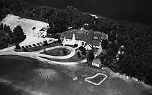 Aerial view of Rockwood Lodge showing the main building, the practice field, the parking lot, and the surrounding property.