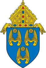 The arms of the Archdiocese of Los Angeles: The arms feature three pairs of wings, denoting three angels, and referencing the namesake of the see, Los Angeles, California, which translates to "the angels."