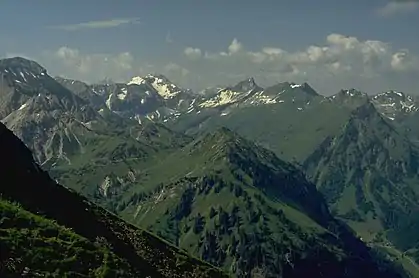 The Giebel (mountain with triangular, partly wooded flank, far right) from the northwestern arête of the Älpelekopf. The grassy mountain front centre is the Roßkopf. High right in the background is the Schneck. Far left is the Glasfelderkopf. Opposite the Schneck is the  Großer Wilder and the snow-filled Gamswanne. Between the Schneck and the Großer Wilder is the  Himmelecksattel.