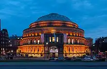 Image 71The Proms are held annually at the Royal Albert Hall during the summer. Regular performers at the Albert Hall include Eric Clapton who has played at the venue over 200 times. (from Culture of the United Kingdom)