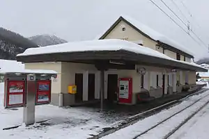 Two-story building with gabled roof next to platforms and tracks