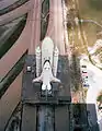 The prototype Space Shuttle Enterprise begins its journey down the Crawlerway from Pad 39A to the VAB in July 1979 following a series of fit-checks