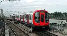 View of the rear of an electric multiple unit crossing a bridge, track in foreground