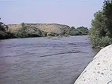 A broad river runs between rocky banks