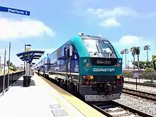 Left: An NCTD Coaster Bombardier BiLevel cab car at San Diego's Santa Fe Depot. Right: Coaster Siemens SC-44 Charger diesel-electric locomotive in Oceanside Transit Center.