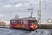 SGP E1 with rolling stock number #945 wrapped in ZTM colors is heading along Katowicka Street toward the Chorzow Rynek transfer center.