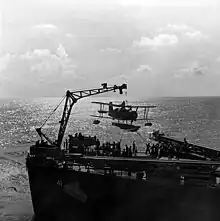 Photo by Horace Bristol of a Curtiss SOC scoutplane being hoisted on board the USS Philadelphia.