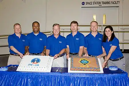 NASA space shuttle astronauts enjoy a cake-cutting event in the Space Station Training Facility at JSC