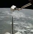 The Induced Environment Contaminant Monitor (IECM) is grappled by the Canadarm.