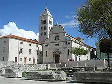 White buildings: a church with round roof in front of building with pointed spire