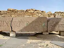 Enormous beam of granite with large hieroglyphs on it, some of which are still green