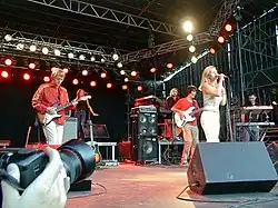 Several people on a stage performing with instruments