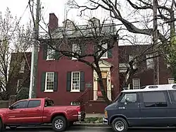 A historic home in Richmond, Virginia. The picture is taken from the front of the residence facing south. The house is federalist style, with red painted brick and a gabled roof.