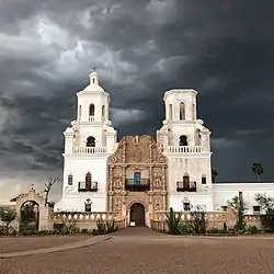 Large white Mexican style church against an overcast sky