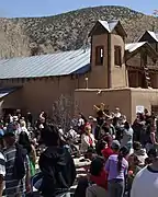 Crowd of pilgrims, including man carrying cross