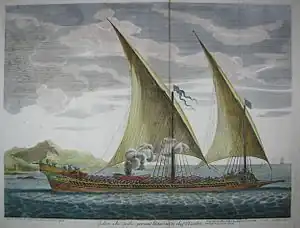 A two-masted ship with sails set