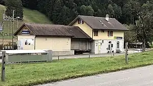 Two-story station building with gabled roof and adjoining single-story freight shed