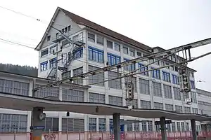 Canopy-covered platform; six-story building looms behind