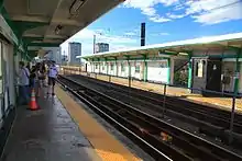 The platforms of an elevated light rail station in an urban area