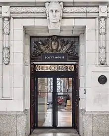 Grand marble doorframe and wooden door with stone face detail