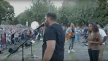 Speakers and musicians in front of crowd