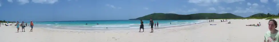 Beachgoers walk on Flamenco Beach