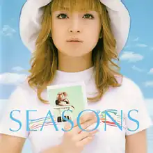 A picture of Ayumi Hamasaki, holding a polaroid image of her single artwork for "Far Away".