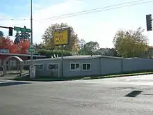 A one-story gray building below a sign saying "The Facts"