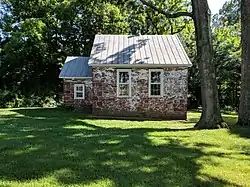 Small old stone building appearing to be one or two rooms.