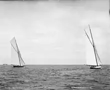 Black and white photograph of two yachts racing under full sail