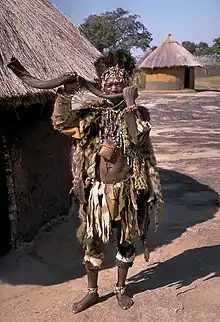 A Shona witch doctor wearing skins and beads