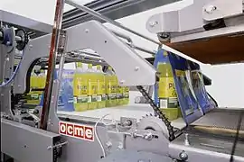 Shrink film wrap being applied to beverage bottles