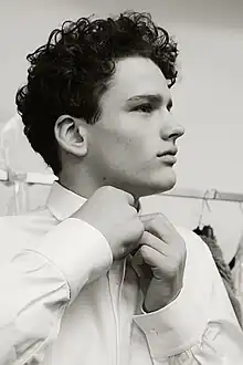 Bust image of Nessman tucking in his shirt collar