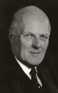 black and white photograph of clean shaven, bald, elderly white man