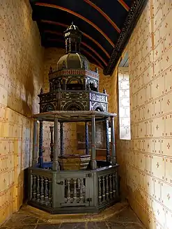 The baldachin over the baptismal font in the Eglise Saint-Suliau. The granite baptismal font is dated 1679. It is surmounted by a canopy or baldachin supported by eight columns, four plain and four ornamented.