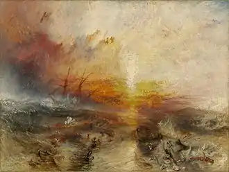 A painting entitled "The Slave Ship" by J. M. W. Turner. In the background, the sun shines through a storm while large waves hit the sides of a sailing ship. In the foreground, enslaved Africans are drowning in the water, while others are being eaten by large fish.