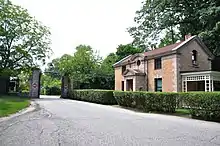 A driveway, gate, and small gatehouse