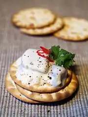 Crackers and herring topped with a garlic sauce