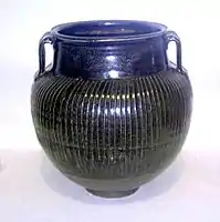 Black vase, with white slip in between the ribs