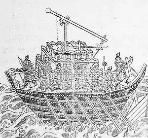 An illustration of a short, wide ship propelled by seven rowers per side. The entire surface area of the deck is occupied by a trebuchet, with a small area in the front for two archers and a small platform in the rear for one man to hold a rod controlling the vessel's rotor.