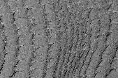 This HiRISE image shows layers running roughly up and down, along with faint polygonal fracturing.  Polygonal fractures are mostly rectangular.