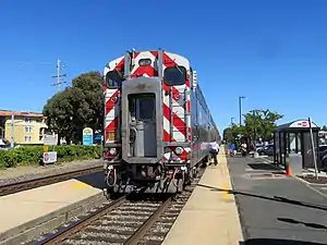 A train at a railroad station with narrow platforms