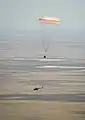 The Soyuz TMA-03M capsule descends past helicopter.