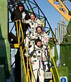 Soyuz TMA-03M crew members wave farewell from the base of the rocket.